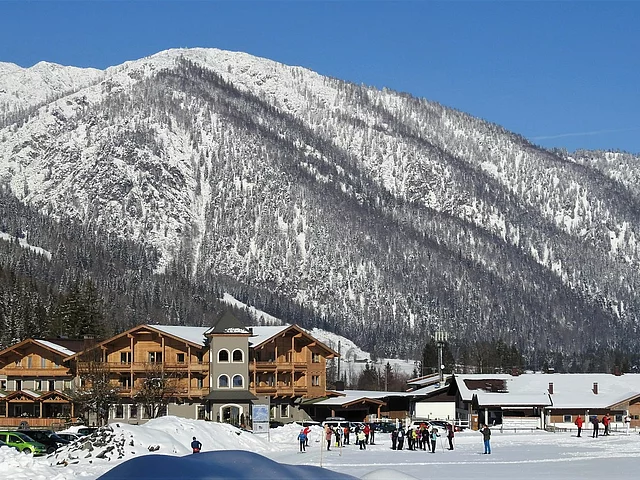 Landhotel Strasserwirt im Winter mit Berg im Hintergrund