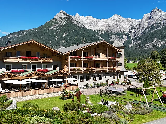 Außenaufnahme des Landhotel Strasserwirt in Tirol mit Bergen im Hintergrund