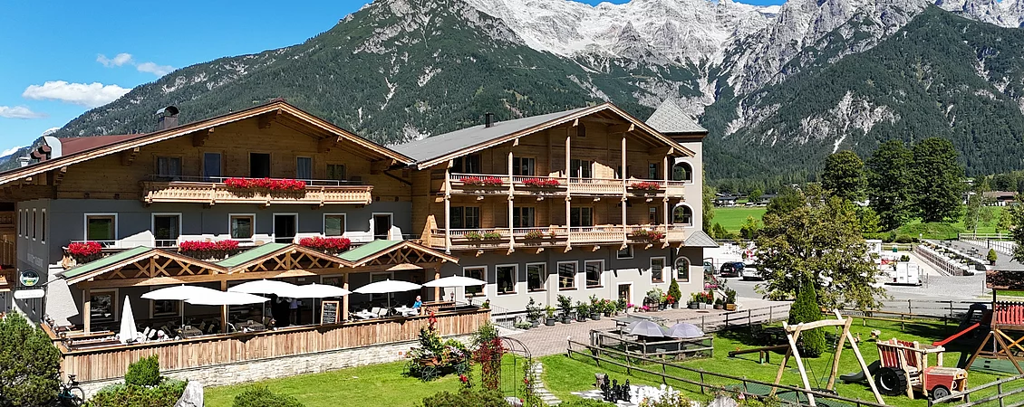 Außenaufnahme des Landhotel Strasserwirt in Tirol mit Bergen im Hintergrund