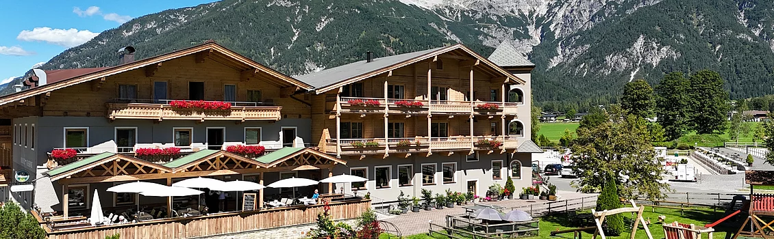 Außenaufnahme des Landhotel Strasserwirt in Tirol mit Bergen im Hintergrund