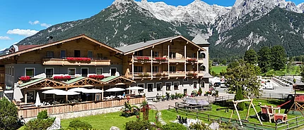 Außenaufnahme des Landhotel Strasserwirt in Tirol mit Bergen im Hintergrund